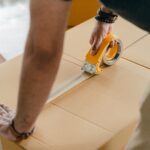 hombre precintando una caja para enviar