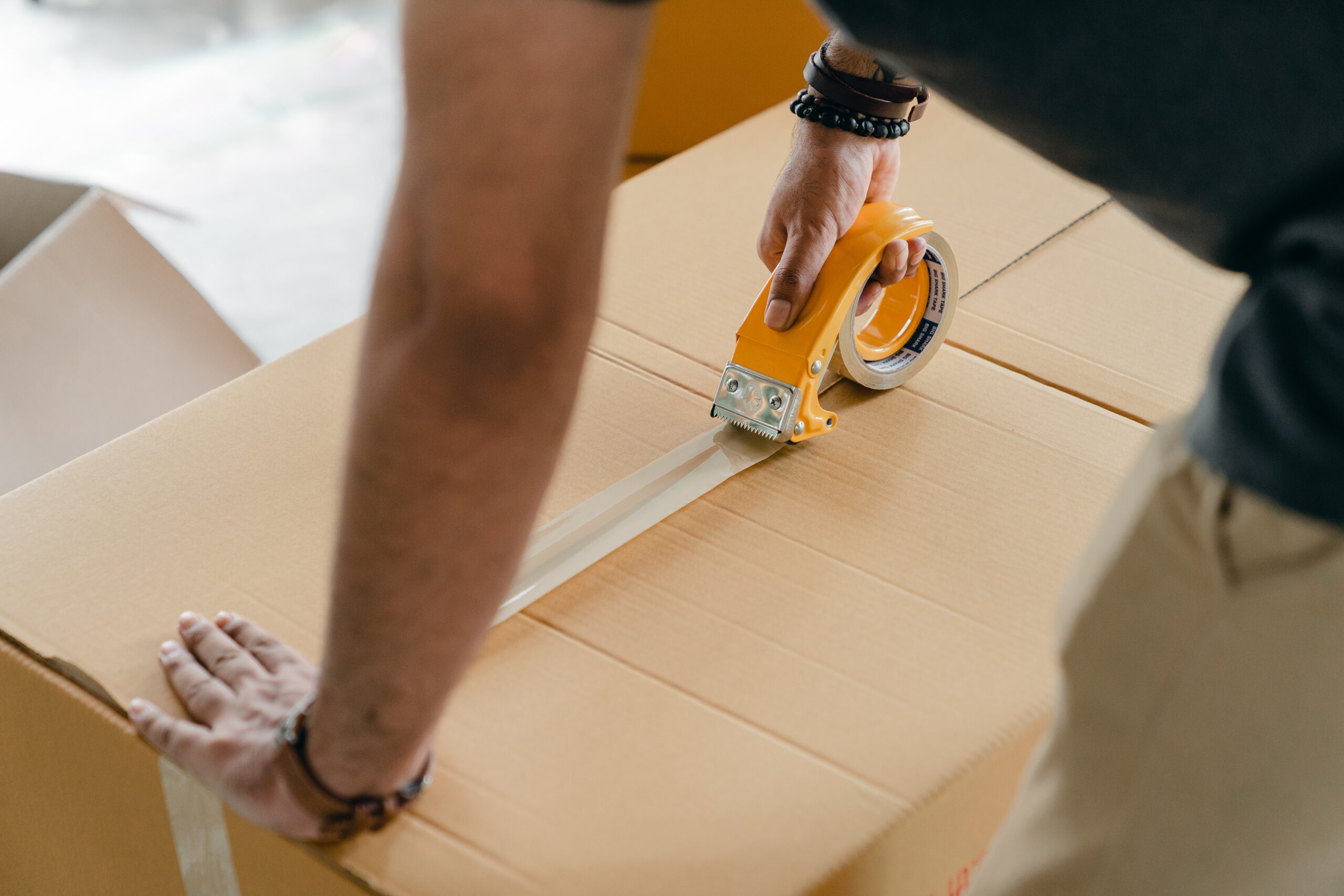 hombre precintando una caja para enviar